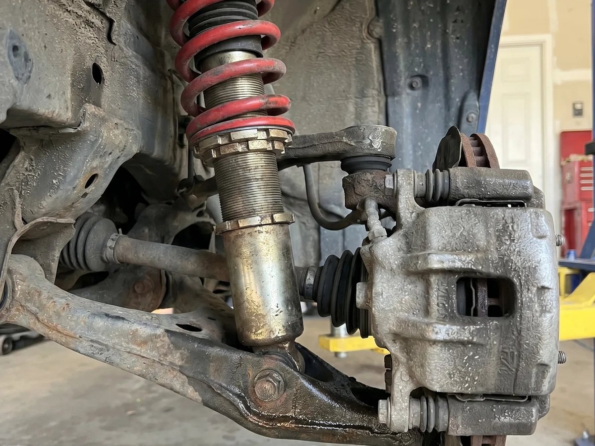 Coil-over strut, control arm and brake assembly on a lifted car
